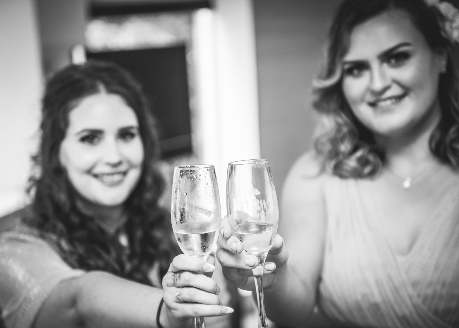 Bridesmaids holding up champagne glasses and posing for Wedding Photography at Loch Ness Country House Hotel