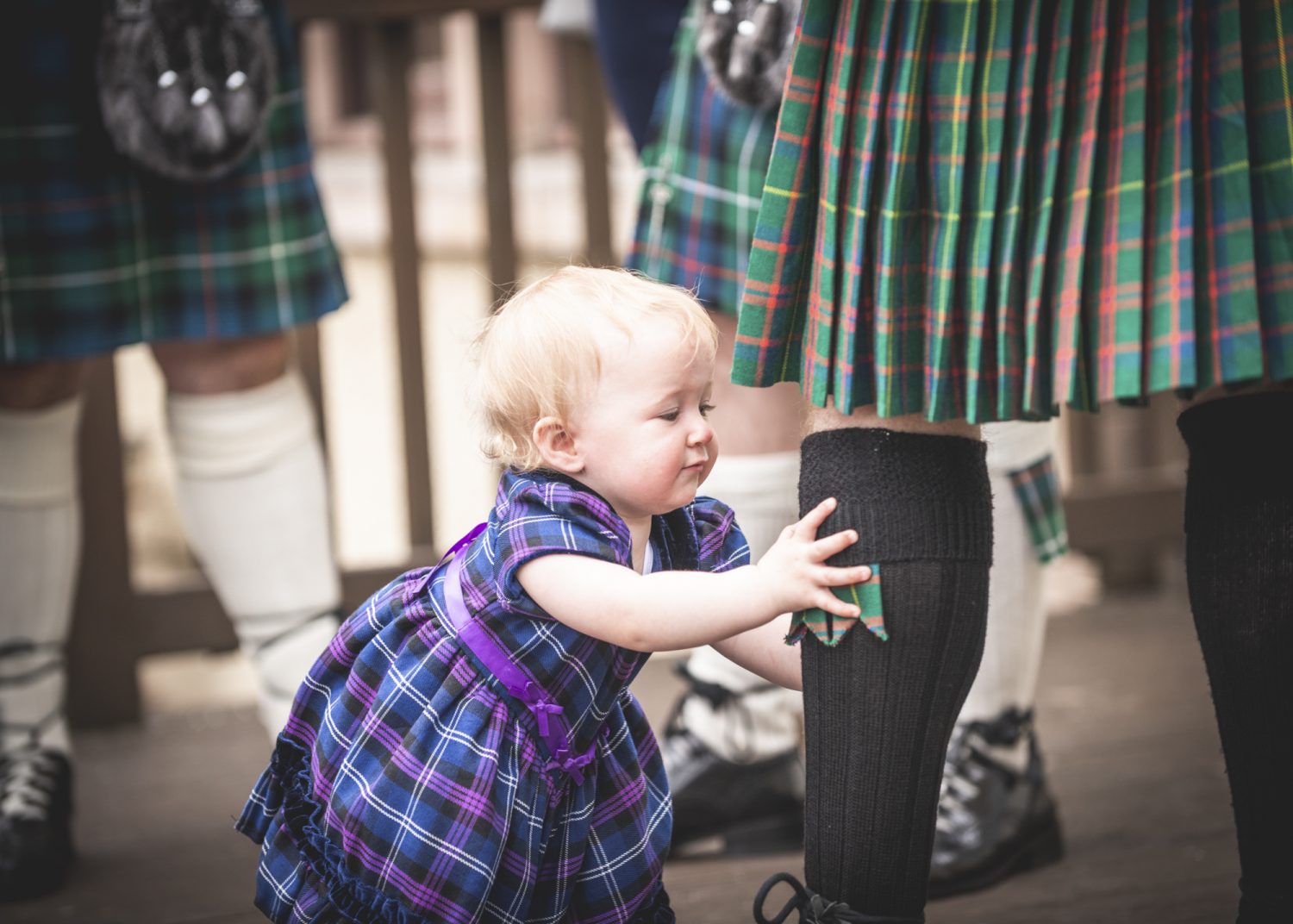 Baby girl grabbing father's leg