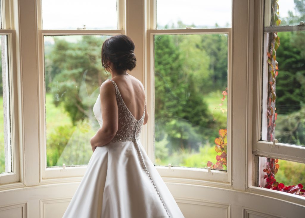 Bride enjoying the view from bedroom window