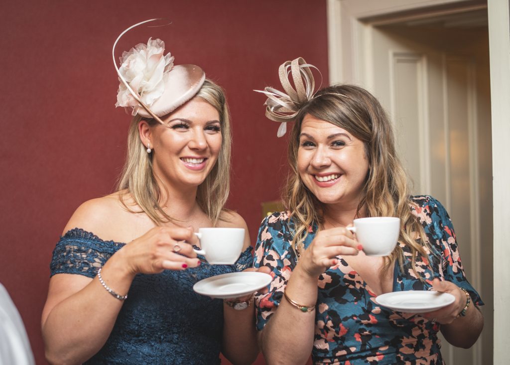Two women with wedding fascinators enjoying a cup of tea at Loch Ness Country House Hotel