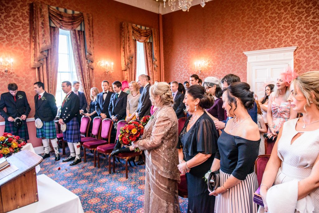 Wedding guests standing during ceremony at Culloden House Hotel wedding