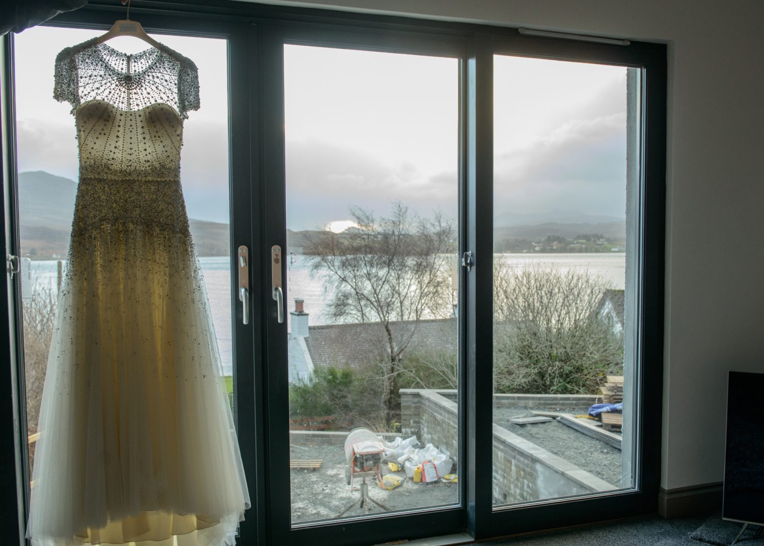 Wedding dress hanging by a window