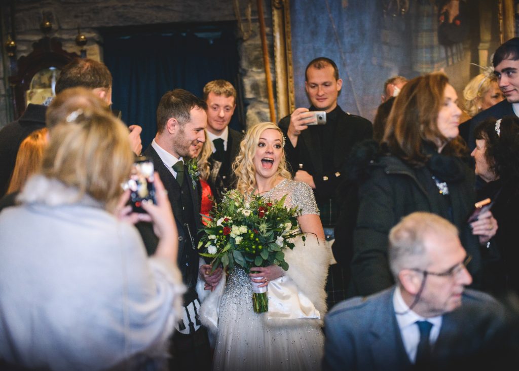 Couple laugh as they leave the Banqueting Hall at Eilean Donan