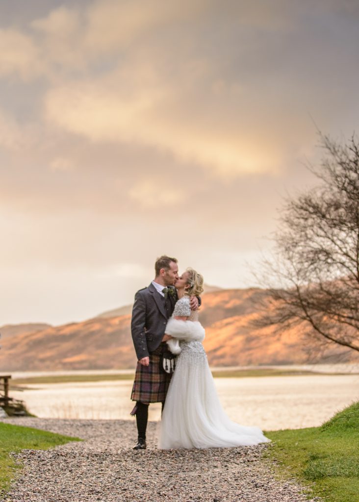 Couple kiss during their Eilean Donan Castle wedding photography