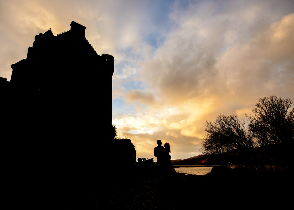 Silhouette of couple beside Eilean Donan Castle